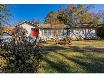 Ranch style home with red door, landscaping, and large yard at 3619 Colonial Trl, Douglasville, GA 30135