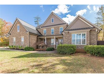 Brick house with a large front porch and three-car garage at 512 Cooper Lake Se Rd, Mableton, GA 30126