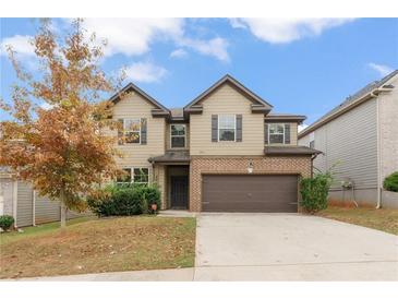 Two-story house with brick and siding, a two-car garage, and landscaping at 4910 Rapahoe Trl, Atlanta, GA 30349