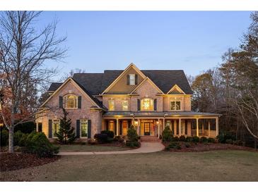 Brick two-story home with large front porch and landscaped yard at 12695 Old Surrey Pl, Roswell, GA 30075