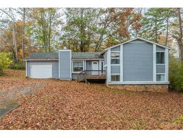 Gray house with attached garage and a yard full of autumn leaves at 9887 Live Oak Ct, Douglasville, GA 30135