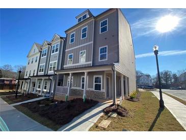 Three-story townhome with gray siding, front porch, and landscaping at 2112 Remy Ct # 47A, Kennesaw, GA 30144
