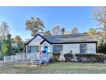 Charming ranch home with white brick exterior, gray roof, and blue front door at 2502 Tupelo Se St, Atlanta, GA 30317