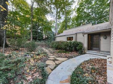 Stone pathway leads to charming home nestled in a wooded setting at 3771 Club Nw Dr, Kennesaw, GA 30144