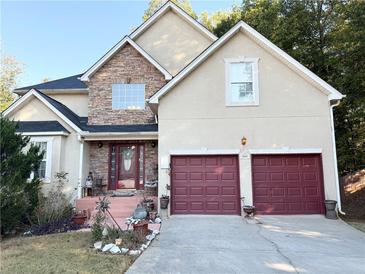 Two-story house with stone accents and a red door at 3668 Deer Springs Pkwy, Ellenwood, GA 30294