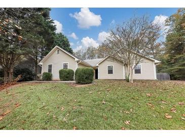 House exterior features a beige vinyl siding, attached garage, and well-maintained lawn at 2392 Ivy Crest Dr, Buford, GA 30519