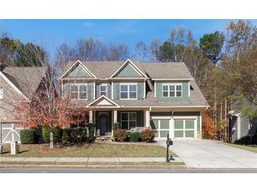 Two story house, green siding, stone accents, two car garage, and landscaping at 645 Wexford Ct, Acworth, GA 30102