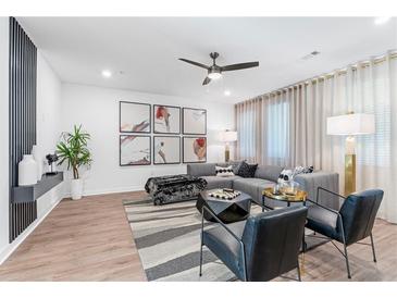 Spacious living room features a comfortable sectional sofa, stylish armchairs, and large-scale art at 392 Pratt Se Dr # 2023, Atlanta, GA 30315