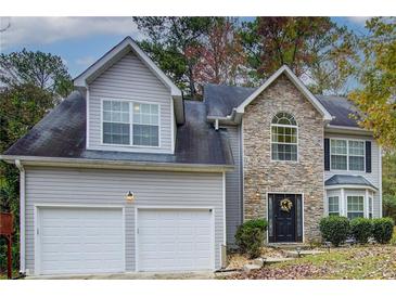 Two-story house with stone accents, two-car garage, and landscaped yard at 3579 Oakshire Se Way, Atlanta, GA 30354