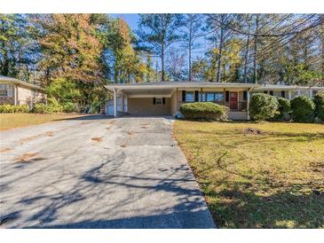 Ranch home with covered carport and well-maintained lawn at 6677 Songwood Dr, Austell, GA 30168