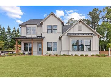 Two-story farmhouse with white brick, gray roof, and a welcoming front porch at 2810 Herrington Dr, Cumming, GA 30041