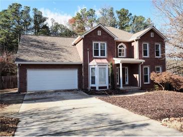 Charming two-story brick home with a white garage door, a covered entryway, and landscaping at 228 N Springs Way, Acworth, GA 30101