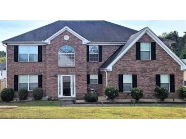 Brick two-story house with black shutters and a well-maintained lawn at 6476 Snowden Dr, Atlanta, GA 30349
