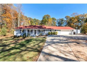 Ranch home with red roof, attached garage, and a spacious front yard at 654 Garner Sw Rd, Lilburn, GA 30047