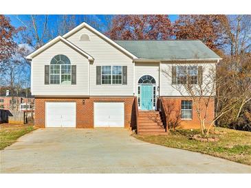 Charming two-story home with a teal front door, two-car garage, and brick and siding exterior at 482 Chase Marion Way, Mcdonough, GA 30253