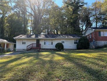 Ranch home with red stairs, nestled on a spacious lawn and surrounded by lush trees at 2053 Juanita St, Decatur, GA 30032