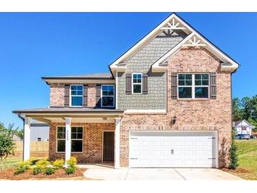 Two-story brick home with gray shake siding, white garage door, and landscaping at 7214 Gladstone Cir, Stonecrest, GA 30038