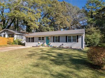 Charming ranch home with gray siding, teal door, and manicured lawn at 1824 Evans Sw Dr, Atlanta, GA 30310