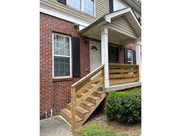 Brick townhouse exterior with a wooden porch and steps at 1651 Massachusetts Sw Ave # 20, Marietta, GA 30008