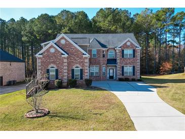 Two-story brick home with a large driveway and landscaped lawn at 168 Waypoint Dr, Stockbridge, GA 30281