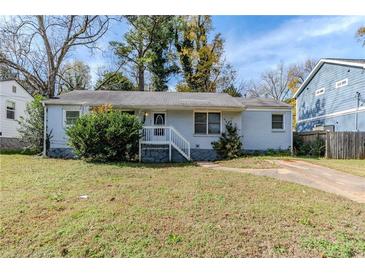 Cute ranch home with light blue exterior, landscaped yard, and driveway at 1965 Meadow Ln, Decatur, GA 30032