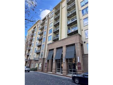 Modern multi-story building with brick and light-colored siding, balconies, and covered entryway at 711 Cosmopolitan Ne Dr # 426, Atlanta, GA 30324