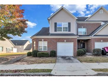 Brick townhouse with a two-car garage and well-maintained landscaping at 2555 Flat Shoals Rd # 1801, Atlanta, GA 30349