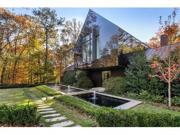 Modern home with black exterior, long water feature, and stone pathway at 2716 Ridgewood Nw Rd, Atlanta, GA 30327