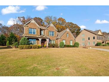 Brick two-story house with a large front yard and landscaping at 3050 Pleasant Valley Trl, Cumming, GA 30028