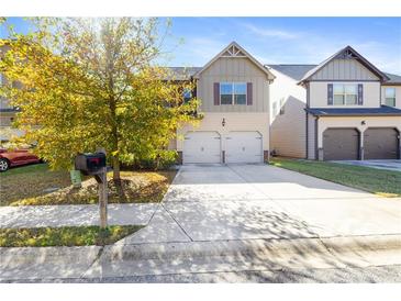 Two-story house with a two-car garage and a landscaped lawn at 318 Emporia Loop, Mcdonough, GA 30253