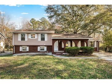 Brick ranch home with a covered porch and well-maintained landscaping at 2670 Foxlair Trl, Atlanta, GA 30349