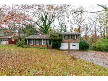 Brick ranch house with attached garage and mature trees at 4796 Fairforest Dr, Stone Mountain, GA 30088