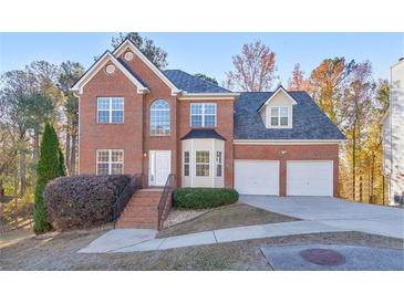 Brick two-story house with a three-car garage and landscaping at 5932 Rosie Se Ln, Mableton, GA 30126