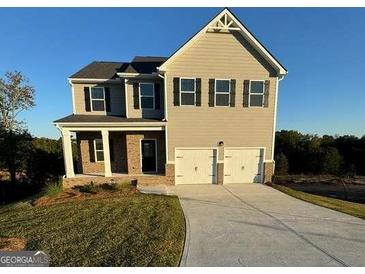 Two-story house with beige siding, three-car garage, and landscaped lawn at 510 Overlook Rd, Covington, GA 30014