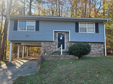 Ranch style home with gray siding, brick foundation, and a paved driveway at 801 Plainville Sw Ter, Atlanta, GA 30331