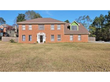 Two-story brick home with a green addition and a large front yard at 4605 Tims Pl, Snellville, GA 30039