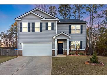 Two-story house with gray siding, white garage door, and landscaped lawn at 25 Lena Ct, Covington, GA 30016