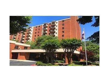 Brick apartment building with landscaped grounds and ample parking at 300 Johnson Ferry Rd # B802, Atlanta, GA 30328