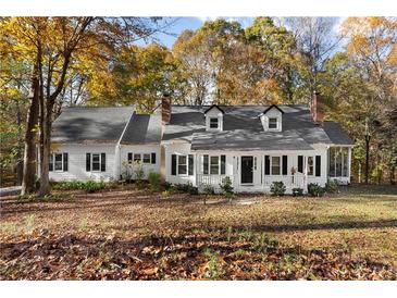 Charming white house with gray roof, surrounded by autumn trees at 3775 Belle Glade Trl, Snellville, GA 30039