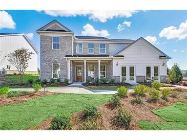 Two-story house with gray and white exterior, landscaping, and a walkway at 3121 Morris Hills Dr, Dacula, GA 30019