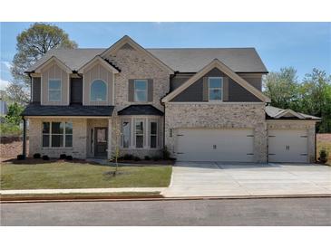 Two-story brick home with a three-car garage and landscaped lawn at 3740 Sierra Lake Dr, Cumming, GA 30040