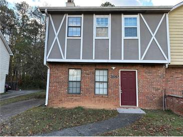 Brick townhouse exterior with a burgundy door and landscaping at 3506 Ten Oaks Ct, Powder Springs, GA 30127