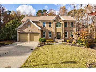 Brick two-story house with two-car garage and landscaped lawn at 1640 Alvecote Ct, Cumming, GA 30041