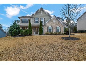 Two story house with neutral siding and brick accents, landscaping and driveway at 147 Stargaze Rdg, Canton, GA 30114