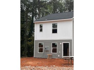 Two-story townhome with gray and white siding, featuring a front door and several windows at 7264 Crestside Dr, Austell, GA 30168