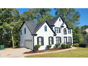 Two story house with white brick and black accents, a two car garage and manicured lawn at 227 Scenic View Lane Ln, Stone Mountain, GA 30087