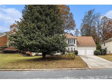 Two-story house with a two car garage and a landscaped lawn at 700 Mountain Oaks Pkwy, Stone Mountain, GA 30087