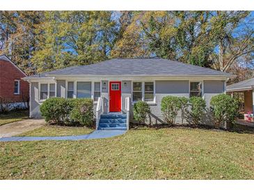 Charming ranch home with gray brick exterior, red front door, and manicured lawn at 2415 Plantation Dr, Atlanta, GA 30344