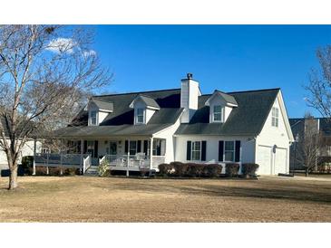 White farmhouse with gray roof, porch, and large yard at 293 Pine Valley Rds, Powder Springs, GA 30127