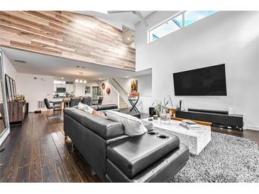 Open living area with high ceilings, hardwood floors, and a modern sectional sofa at 241 Maynard Se Ter # 31, Atlanta, GA 30316